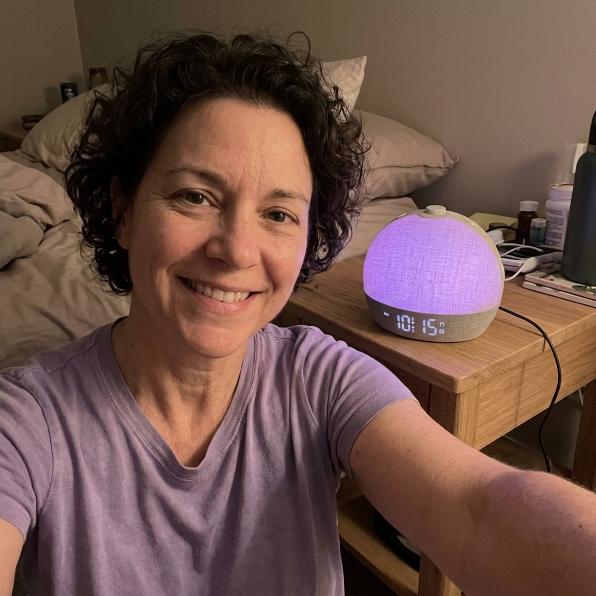 Woman taking an evening selfie beside Daybreak glowing purple